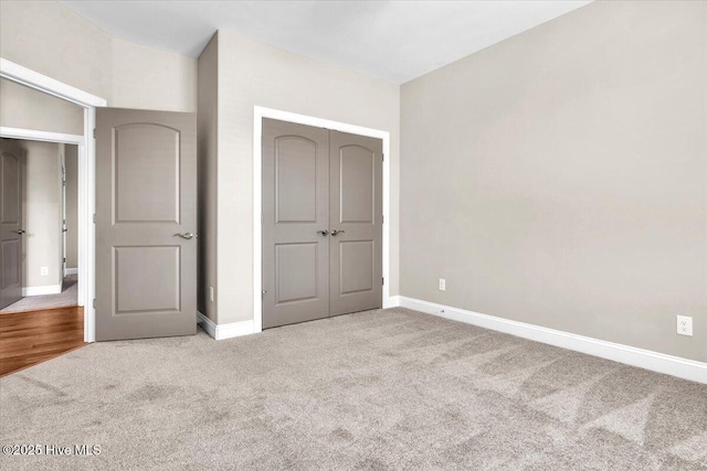 unfurnished bedroom featuring light colored carpet and a closet