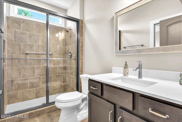 bathroom featuring vanity, walk in shower, and toilet