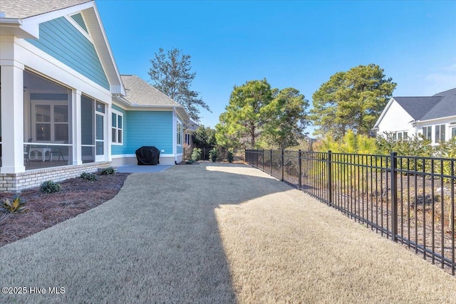 view of yard featuring a sunroom and a patio