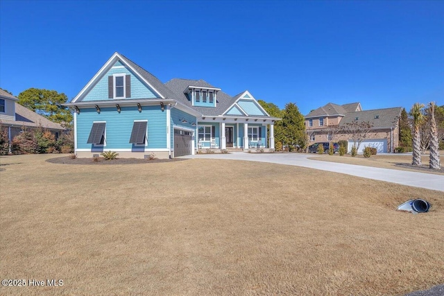 view of front of house with a garage, a front yard, and a porch