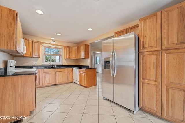 kitchen featuring white appliances, sink, and light tile patterned floors