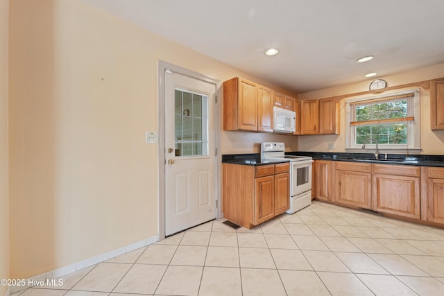 kitchen featuring sink, light tile patterned floors, and white appliances