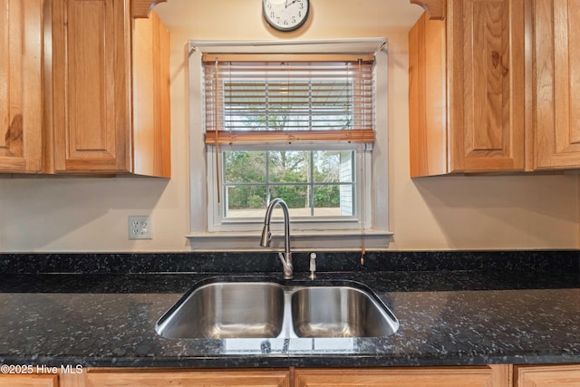 kitchen featuring sink and dark stone countertops