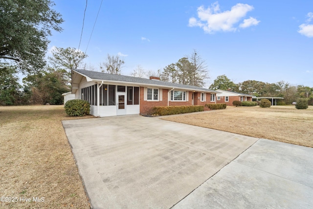 ranch-style house with a sunroom and a front lawn