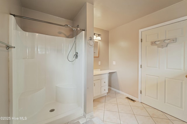 bathroom with walk in shower, tile patterned floors, and vanity