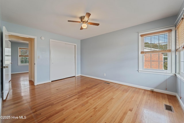 unfurnished bedroom featuring ceiling fan, a closet, and light hardwood / wood-style flooring