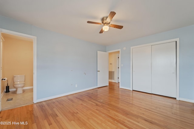 unfurnished bedroom with a closet, connected bathroom, and light hardwood / wood-style flooring