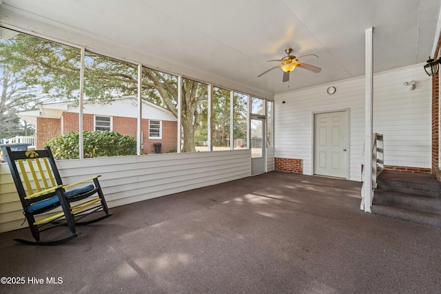 unfurnished sunroom with ceiling fan