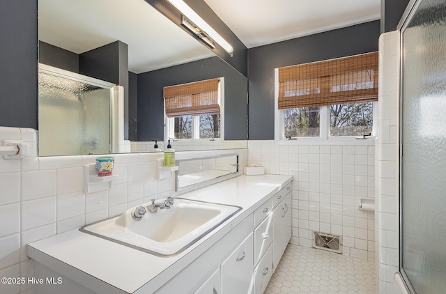 bathroom featuring vanity, tile walls, an enclosed shower, and tile patterned floors