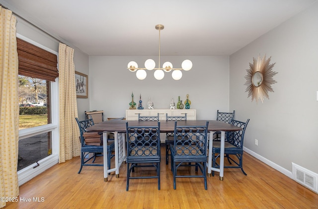 dining space featuring an inviting chandelier and light wood-type flooring