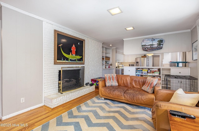 living room featuring a brick fireplace, crown molding, and light wood-type flooring