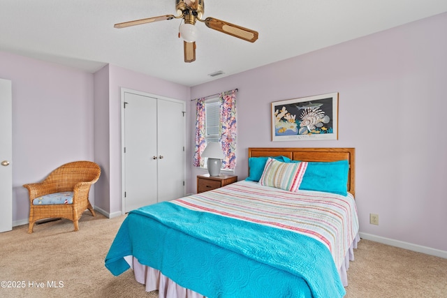 bedroom with light colored carpet, ceiling fan, and a closet