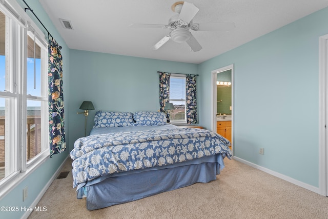 bedroom with ceiling fan, connected bathroom, and light carpet