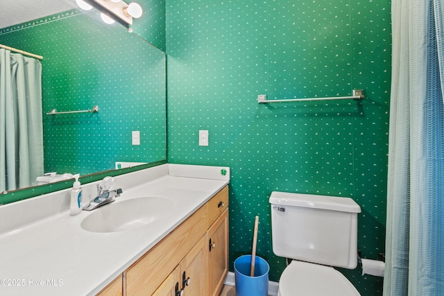 bathroom featuring sink, curtained shower, and toilet