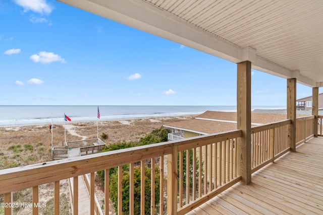 wooden deck featuring a water view and a beach view