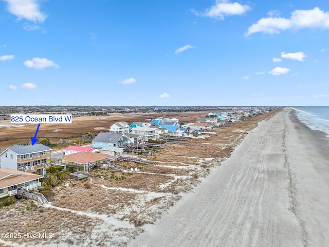 birds eye view of property with a water view and a beach view