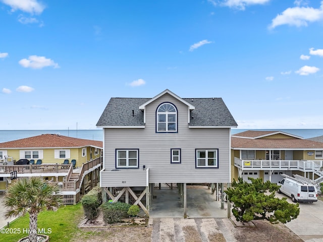 rear view of house with a carport and a water view