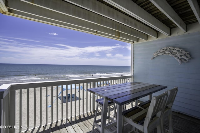 balcony featuring a water view and a beach view