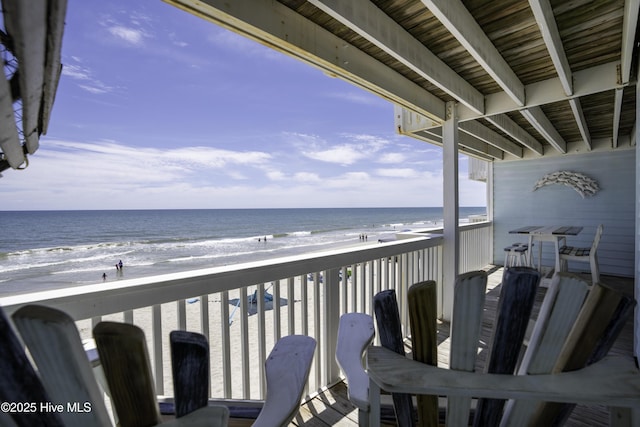 balcony featuring a beach view and a water view