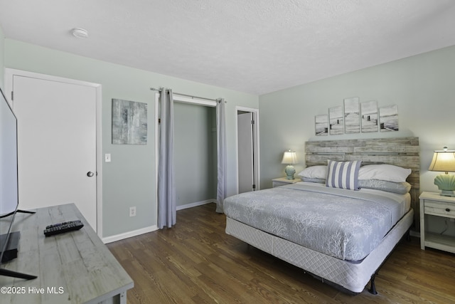 bedroom featuring dark wood-type flooring, a closet, and a textured ceiling