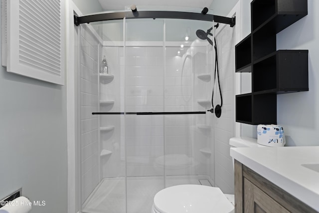 bathroom with vanity, an enclosed shower, and toilet