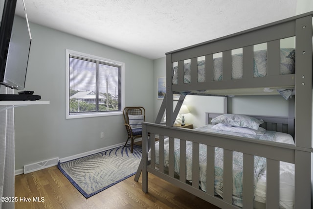 bedroom featuring hardwood / wood-style floors and a textured ceiling