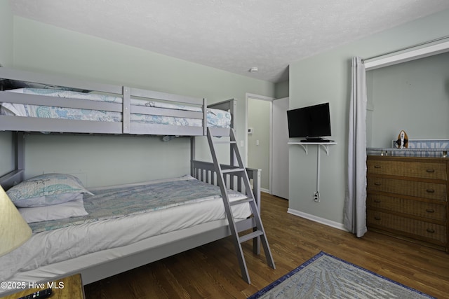 bedroom with dark hardwood / wood-style flooring and a textured ceiling