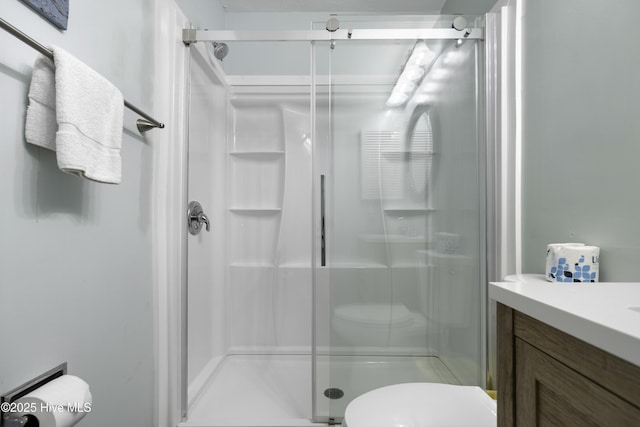 bathroom with toilet, vanity, and walk in shower