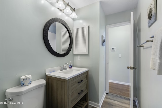 bathroom featuring hardwood / wood-style flooring, vanity, and toilet