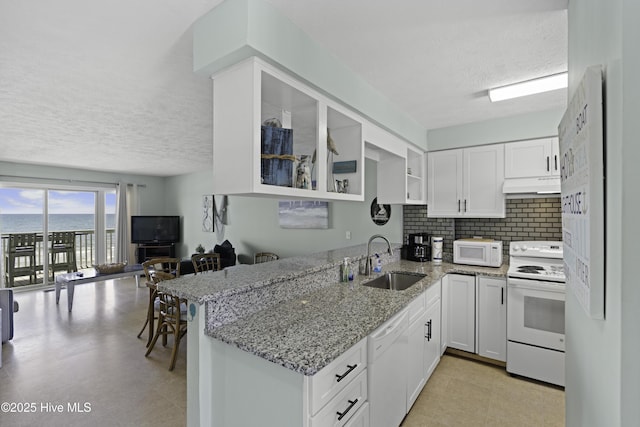 kitchen featuring white appliances, kitchen peninsula, sink, and white cabinets