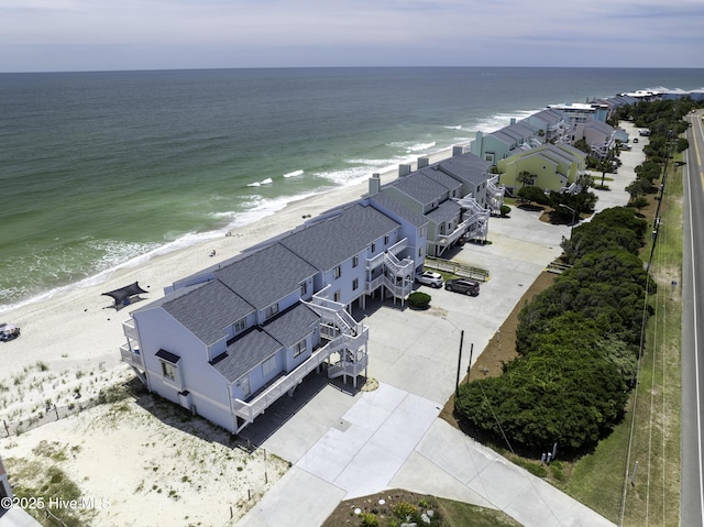 drone / aerial view with a water view and a beach view