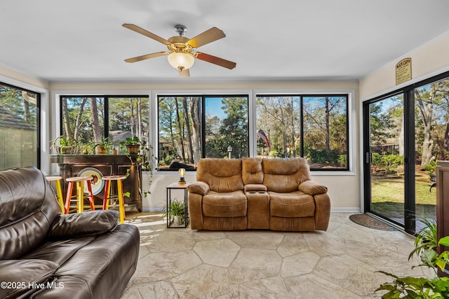 sunroom / solarium featuring a ceiling fan and a healthy amount of sunlight