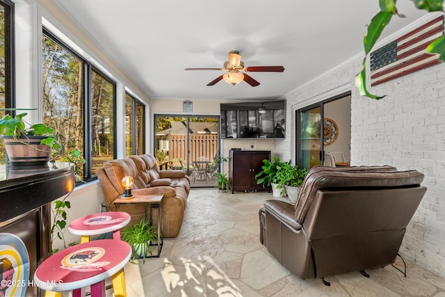 sunroom / solarium featuring a healthy amount of sunlight and ceiling fan