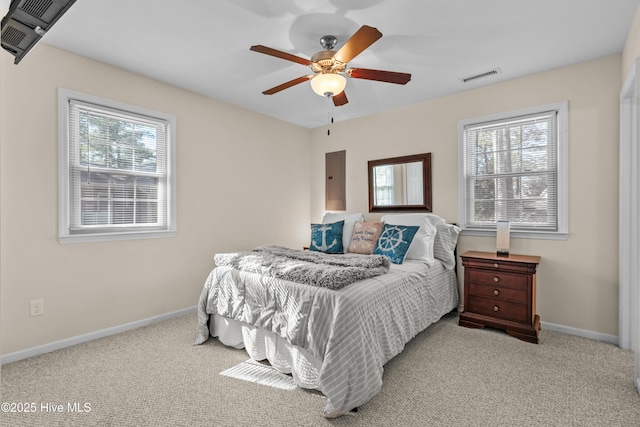 bedroom with visible vents, light carpet, ceiling fan, electric panel, and baseboards