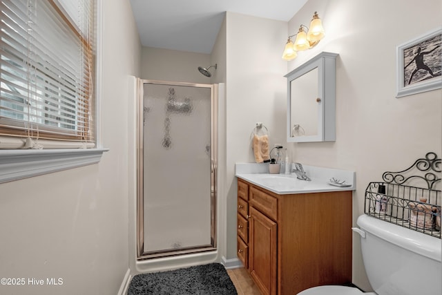 full bathroom featuring toilet, a shower stall, baseboards, and vanity