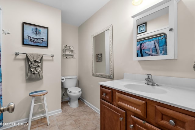 bathroom featuring tile patterned flooring, baseboards, vanity, and toilet