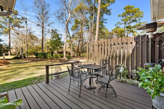 deck featuring outdoor dining area and a yard