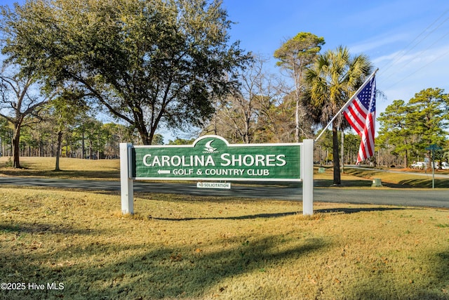 community / neighborhood sign featuring a lawn