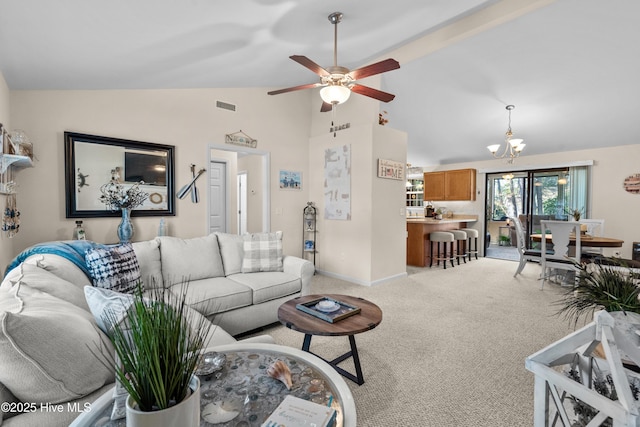 living room featuring light carpet, ceiling fan with notable chandelier, visible vents, baseboards, and vaulted ceiling