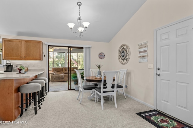 dining area featuring light carpet, baseboards, lofted ceiling, and an inviting chandelier