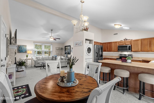 dining area with lofted ceiling, light carpet, visible vents, and stacked washer and clothes dryer