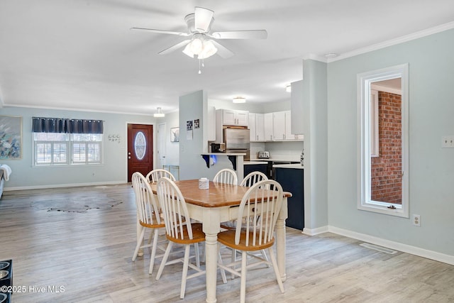 dining space with crown molding, ceiling fan, and light wood-type flooring