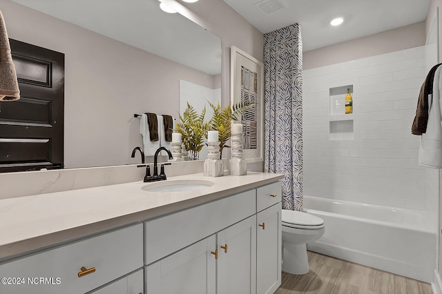 full bathroom with hardwood / wood-style flooring, vanity, toilet, and shower / bath combo