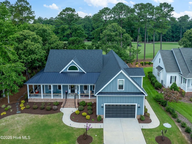 1611 Golfers Ridge Dr SE, Bolivia, NC 28422 - view of front facade with board and batten siding, a porch, driveway, and a front yard
