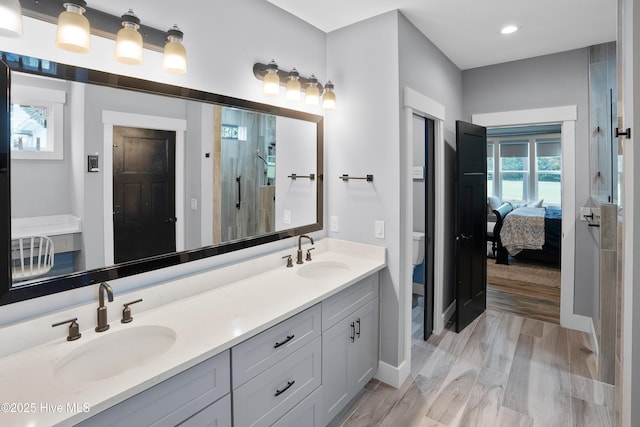 1611 Golfers Ridge Dr SE, Bolivia, NC 28422 - ensuite bathroom with double vanity, wood finished floors, a shower with door, and recessed lighting