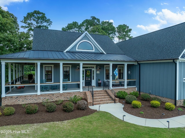 1611 Golfers Ridge Dr SE, Bolivia, NC 28422 - view of front facade featuring a porch, board and batten siding, a standing seam roof, a metal roof, and a shingled roof