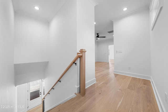 stairway featuring crown molding, hardwood / wood-style floors, and ceiling fan