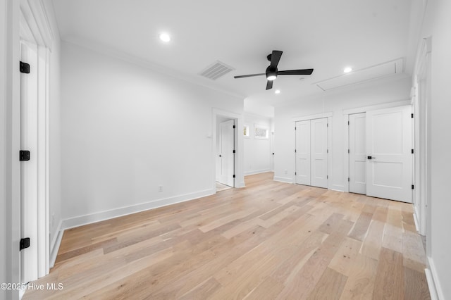 unfurnished bedroom with multiple closets, ceiling fan, and light wood-type flooring