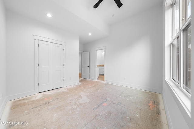 unfurnished bedroom featuring ceiling fan, ensuite bath, and a closet