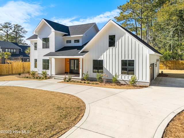 modern inspired farmhouse featuring a porch and a garage